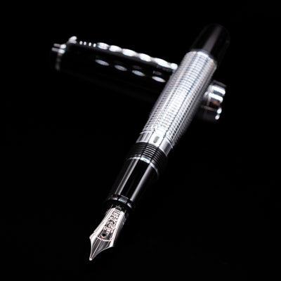 Nagasawa Original Limited Edition Fountain Pen - Engrave Kou laying across its own cap, crossed, with a focus on the nib.
