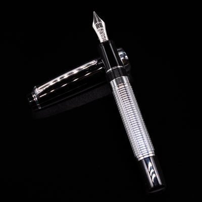 Nagasawa Original Limited Edition Fountain Pen - Engrave Kou laying on top of its cap in a crossed position showing full view of the entire uncapped pen.