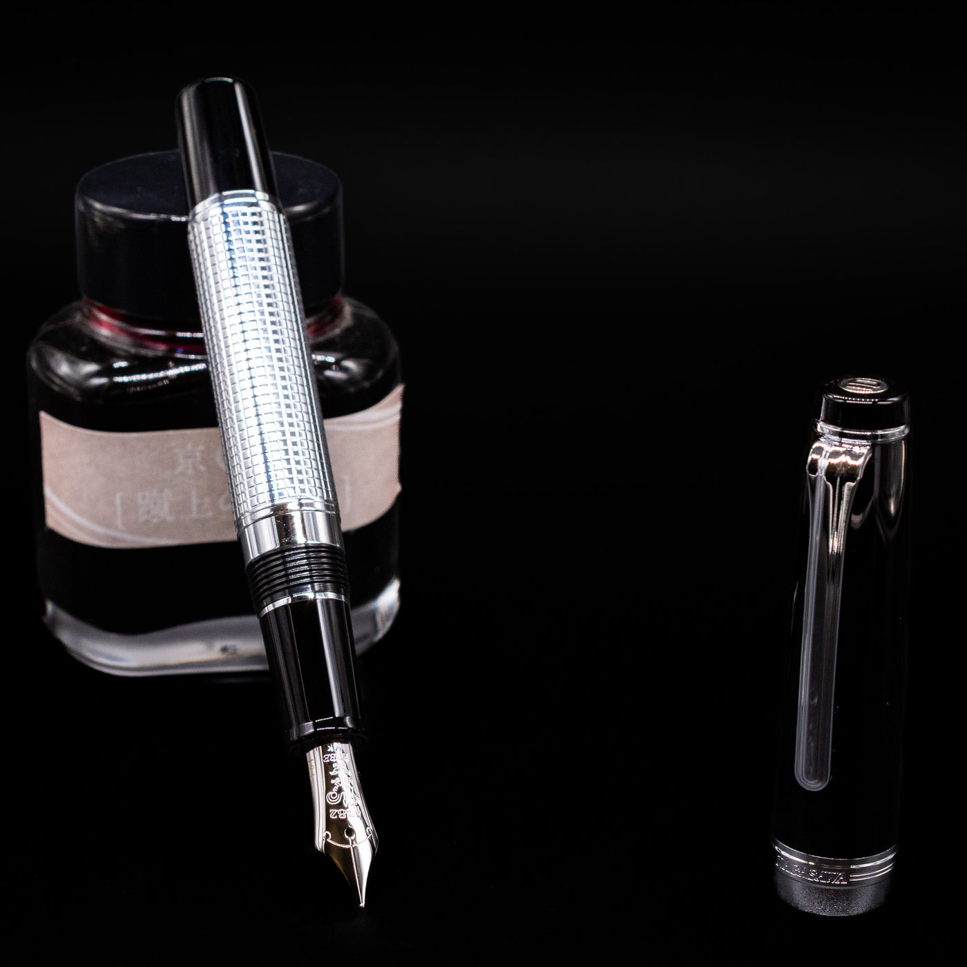 Nagasawa Original Limited Edition Fountain Pen - Engrave Kou leaning on an ink bottle uncapped showcasing the detailing on the nib.