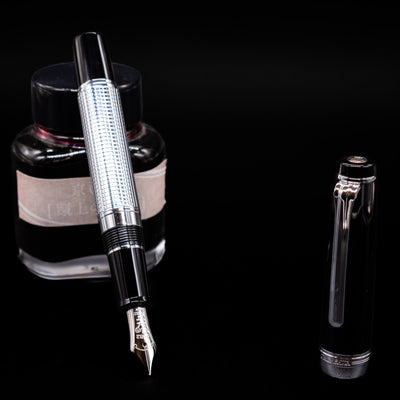 Nagasawa Original Limited Edition Fountain Pen - Engrave Kou leaning on an ink bottle uncapped showcasing the detailing on the nib.