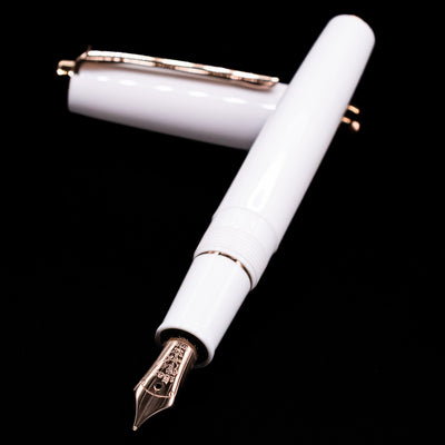 Nagasawa Original Limited Edition Fountain Pen - Odyssey Snow White laying across its own cap, crossed, with a focus on the nib.