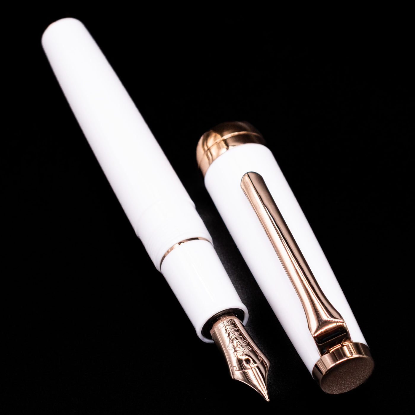 A full view of the Nagasawa Original Limited Edition Fountain Pen - Odyssey Snow White uncapped, with its cap laying next to the pen. 