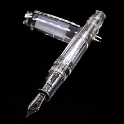 Nagasawa Original Professional Gear Fountain Pen - Skeleton Black laying across its own cap, crossed, with a focus on the nib.