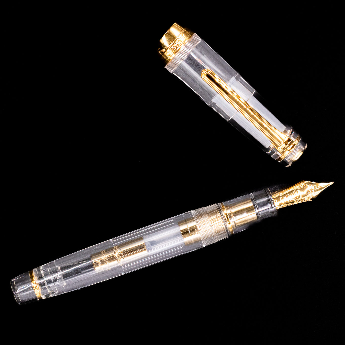 An overhead view of the Nagasawa Original Professional Gear Fountain Pen - Skeleton Gold uncapped.