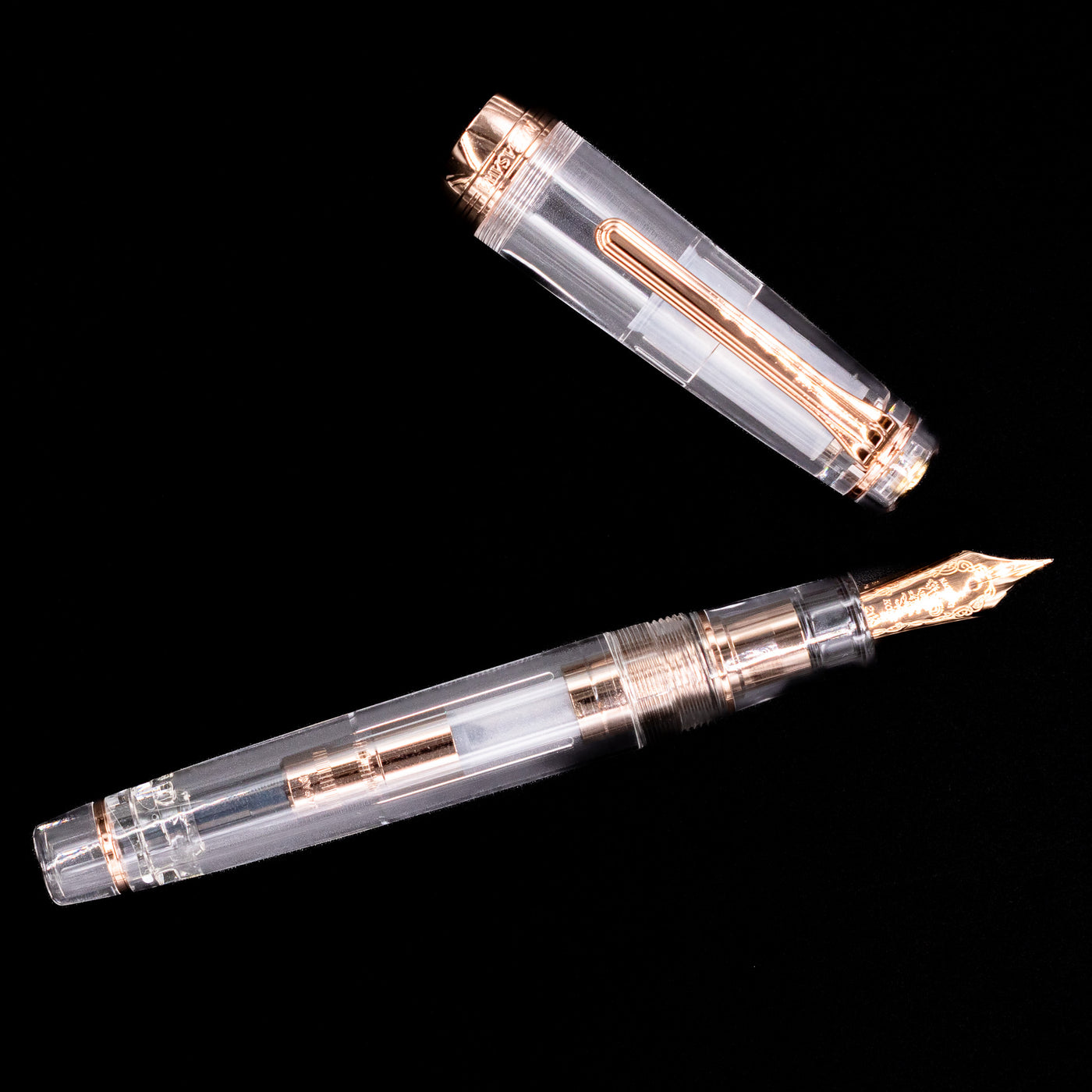 An overhead view of the Nagasawa Original Professional Gear Fountain Pen - Skeleton Pink Gold uncapped.