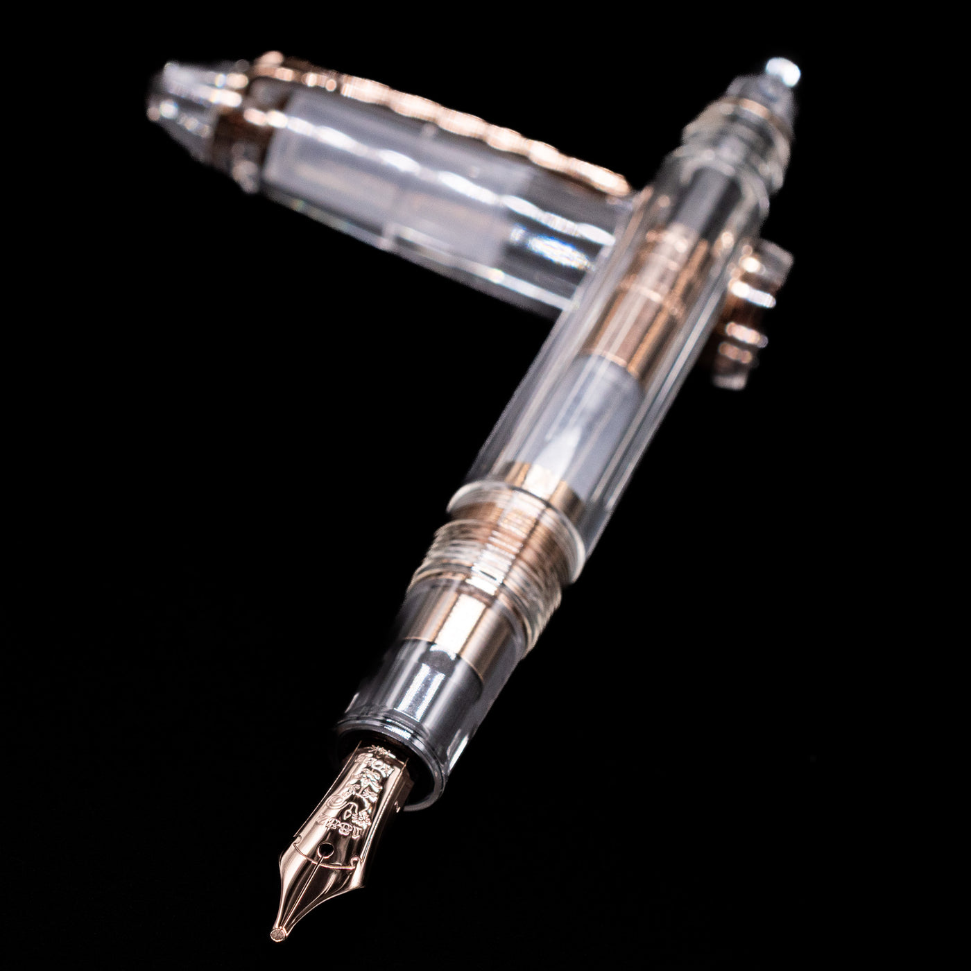 Nagasawa Original Standard Fountain Pen - Skeleton Proske Antique Gold laying across its own cap, crossed, with a focus on the nib.