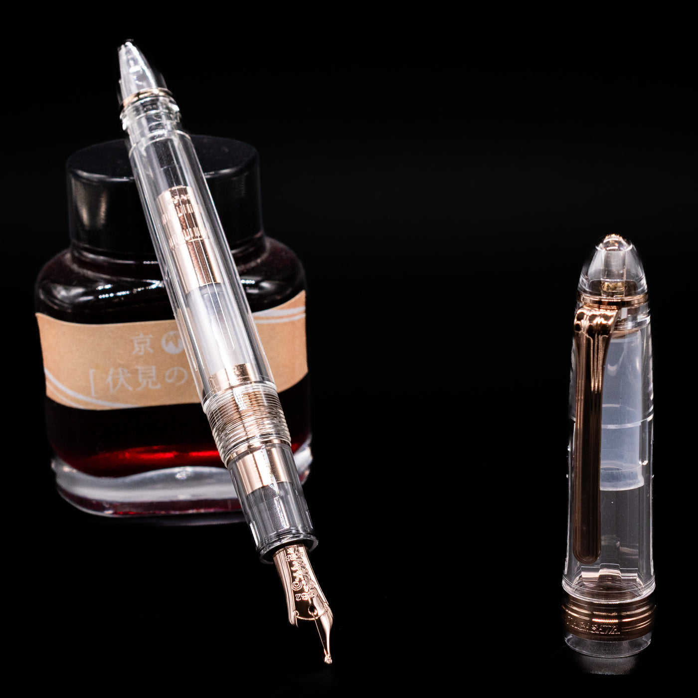 Nagasawa Original Standard Fountain Pen - Skeleton Proske Antique Gold leaning on an ink bottle uncapped showcasing the detailing on the nib.