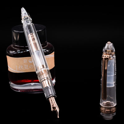 Nagasawa Original Standard Fountain Pen - Skeleton Proske Antique Gold leaning on an ink bottle uncapped showcasing the detailing on the nib.