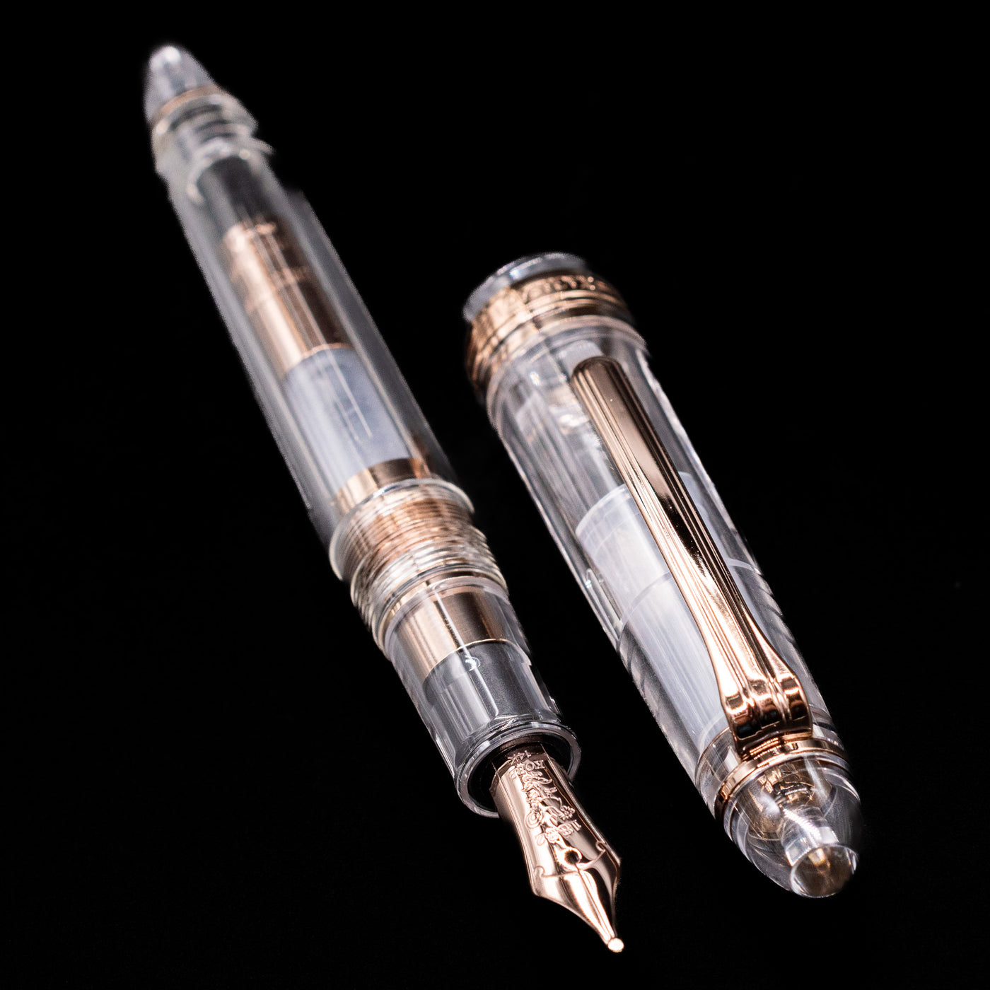 A full view of the Nagasawa Original Standard Fountain Pen - Skeleton Proske Antique Gold uncapped, with its cap laying next to the pen. 