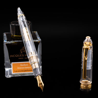 Nagasawa Original Standard Fountain Pen - Skeleton Proske Gold leaning on an ink bottle uncapped showcasing the detailing on the nib.