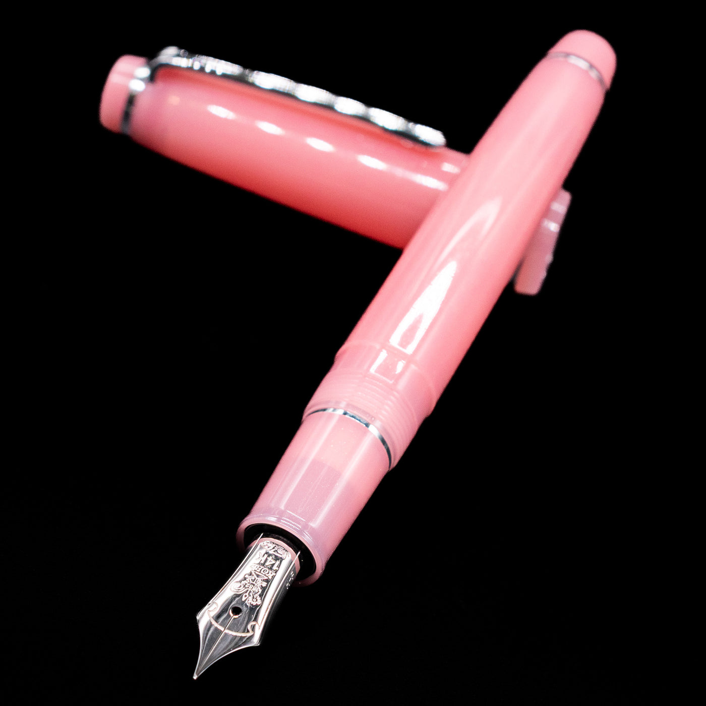 Nagasawa Original Standard Onomatopoeia Fountain Pen - Doki Doki laying across its own cap, crossed, with a focus on the nib.