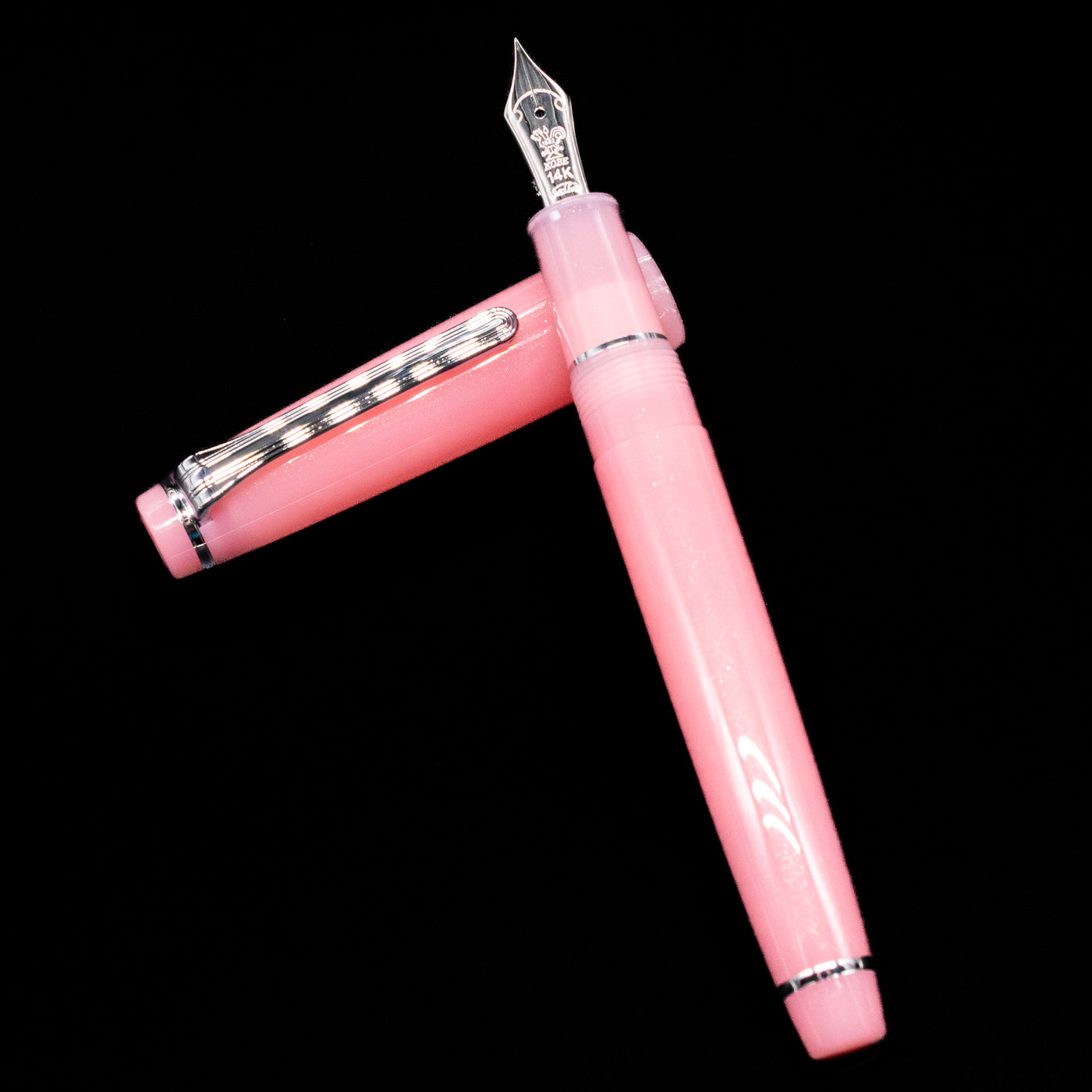 Nagasawa Original Standard Onomatopoeia Fountain Pen - Doki Doki laying on top of its cap in a crossed position showing full view of the entire uncapped pen.