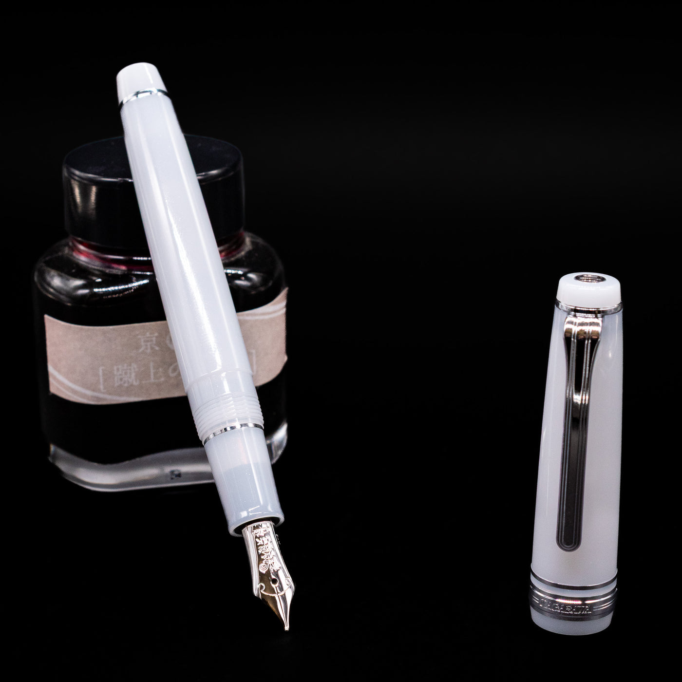 Nagasawa Original Standard Onomatopoeia Fountain Pen - Kasya Kasya leaning on an ink bottle uncapped showcasing the detailing on the nib.