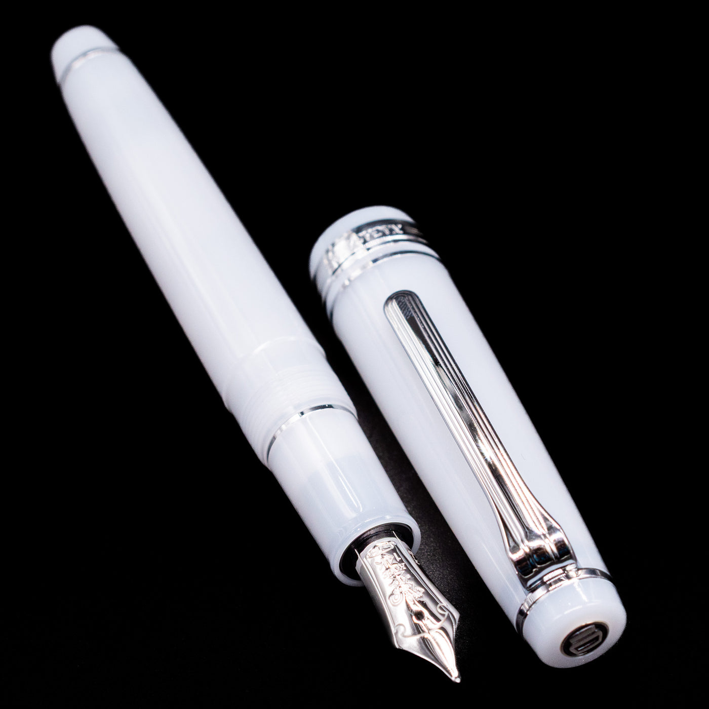  A full view of the Nagasawa Original Standard Onomatopoeia Fountain Pen - Kasya Kasya uncapped, with its cap laying next to the pen. 