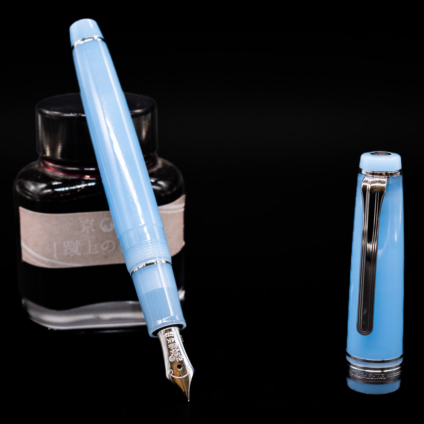Nagasawa Original Standard Onomatopoeia Fountain Pen - Puka Puka leaning on an ink bottle uncapped showcasing the detailing on the nib.
