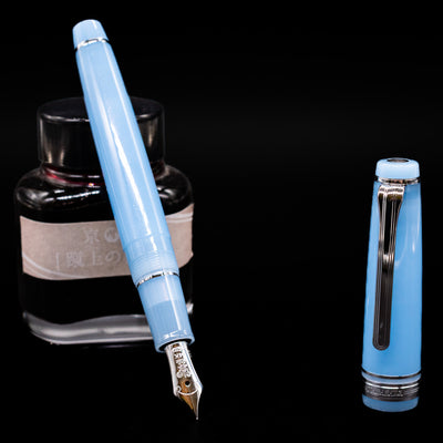 Nagasawa Original Standard Onomatopoeia Fountain Pen - Puka Puka leaning on an ink bottle uncapped showcasing the detailing on the nib.