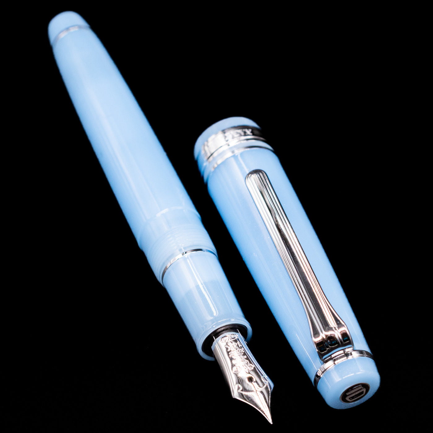 A full view of the Nagasawa Original Standard Onomatopoeia Fountain Pen - Puka Puka uncapped, with its cap laying next to the pen. 