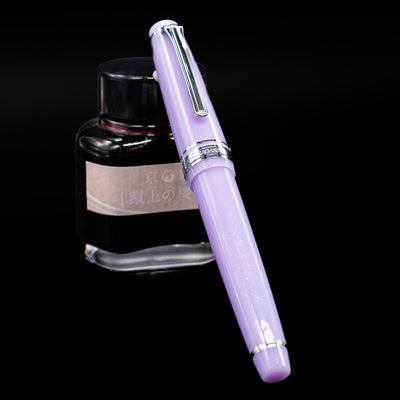 Nagasawa Original Standard Onomatopoeia Fountain Pen - Yura Yura capped, leaning against an ink bottle. 