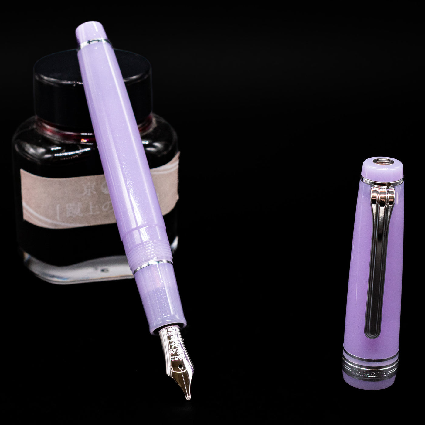 Nagasawa Original Standard Onomatopoeia Fountain Pen - Yura Yura leaning on an ink bottle uncapped showcasing the detailing on the nib.