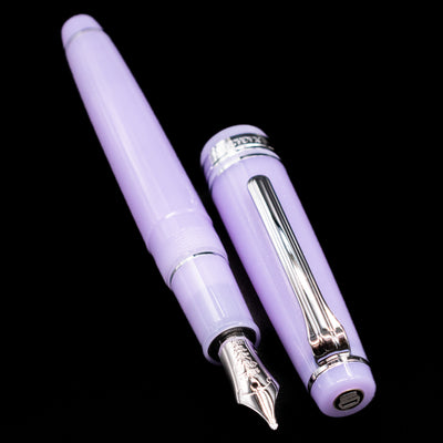 A full view of the Nagasawa Original Standard Onomatopoeia Fountain Pen - Yura Yura uncapped, with its cap laying next to the pen. 