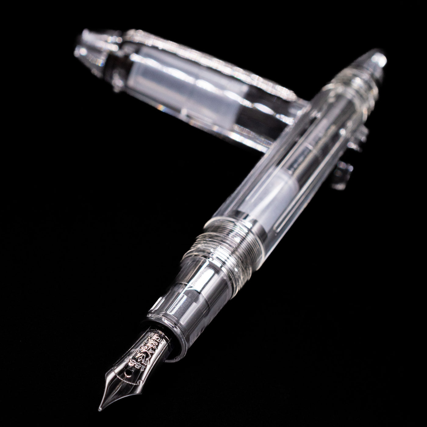 Nagasawa Original Standard Fountain Pen - Skeleton Proske Black laying across its own cap, crossed, with a focus on the nib.