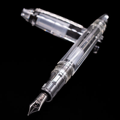 Nagasawa Original Standard Fountain Pen - Skeleton Proske Black laying across its own cap, crossed, with a focus on the nib.