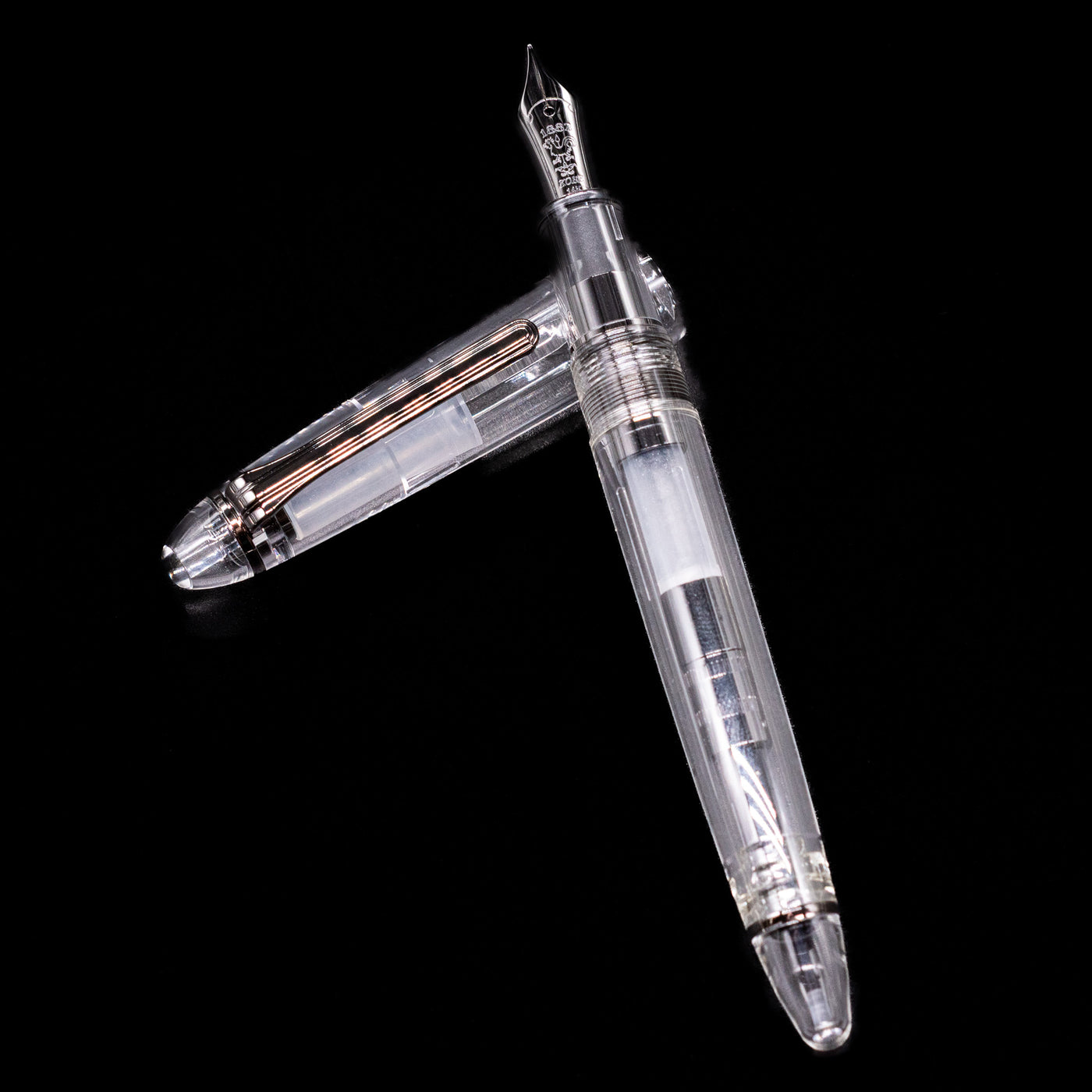 Nagasawa Original Standard Fountain Pen - Skeleton Proske Black laying on top of its cap in a crossed position showing full view of the entire uncapped pen.
