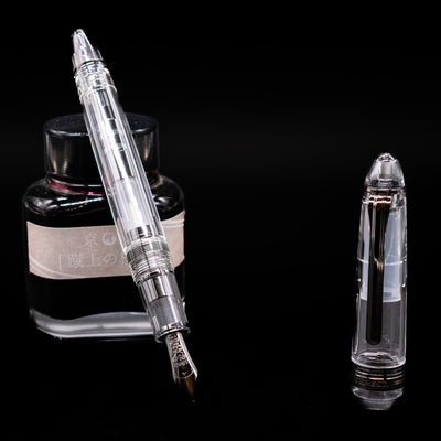 Nagasawa Original Standard Fountain Pen - Skeleton Proske Black leaning on an ink bottle uncapped showcasing the detailing on the nib.