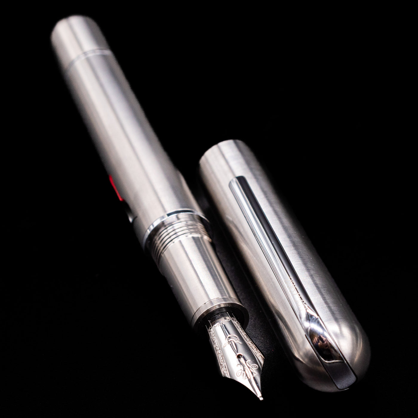 A full view of the Nahvalur Dracula Fountain Pen uncapped, with its cap laying next to the pen. 