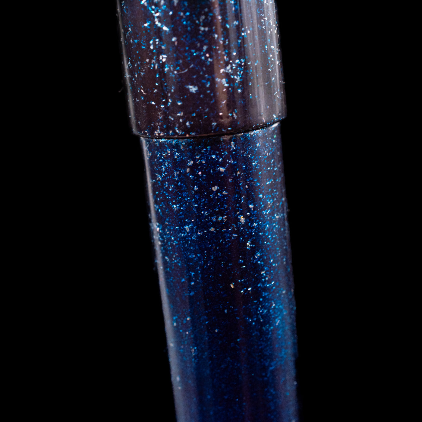 A close-up view of the body of the Nahvalur Ikkaku Urushi Fountain Pen - Blue Moon showcasing the colorful sparkle details. 