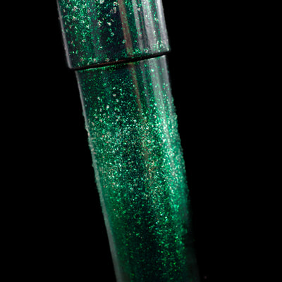 A close-up view of the body of the Nahvalur Ikkaku Urushi Fountain Pen - Green Moon showcasing the colorful sparkle details. 