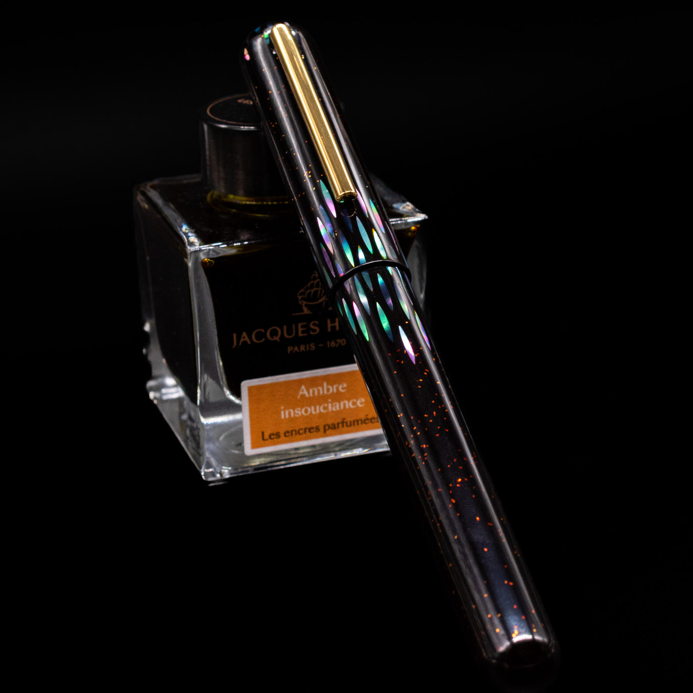 Nahvalur Ikkaku Urushi Fountain Pen - Ye Yu capped, leaning against an ink bottle. 