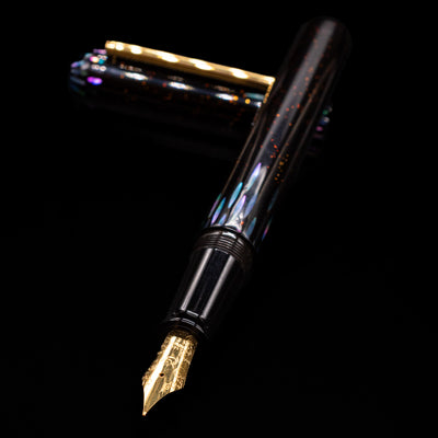 Nahvalur Ikkaku Urushi Fountain Pen - Ye Yu laying across its own cap, crossed, with a focus on the nib.