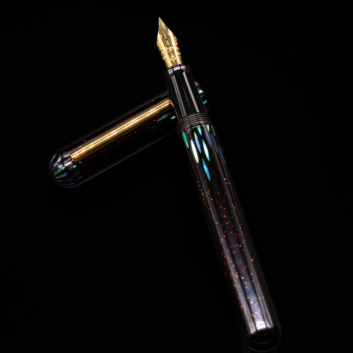 Nahvalur Ikkaku Urushi Fountain Pen - Ye Yu laying on top of its cap in a crossed position showing full view of the entire uncapped pen.