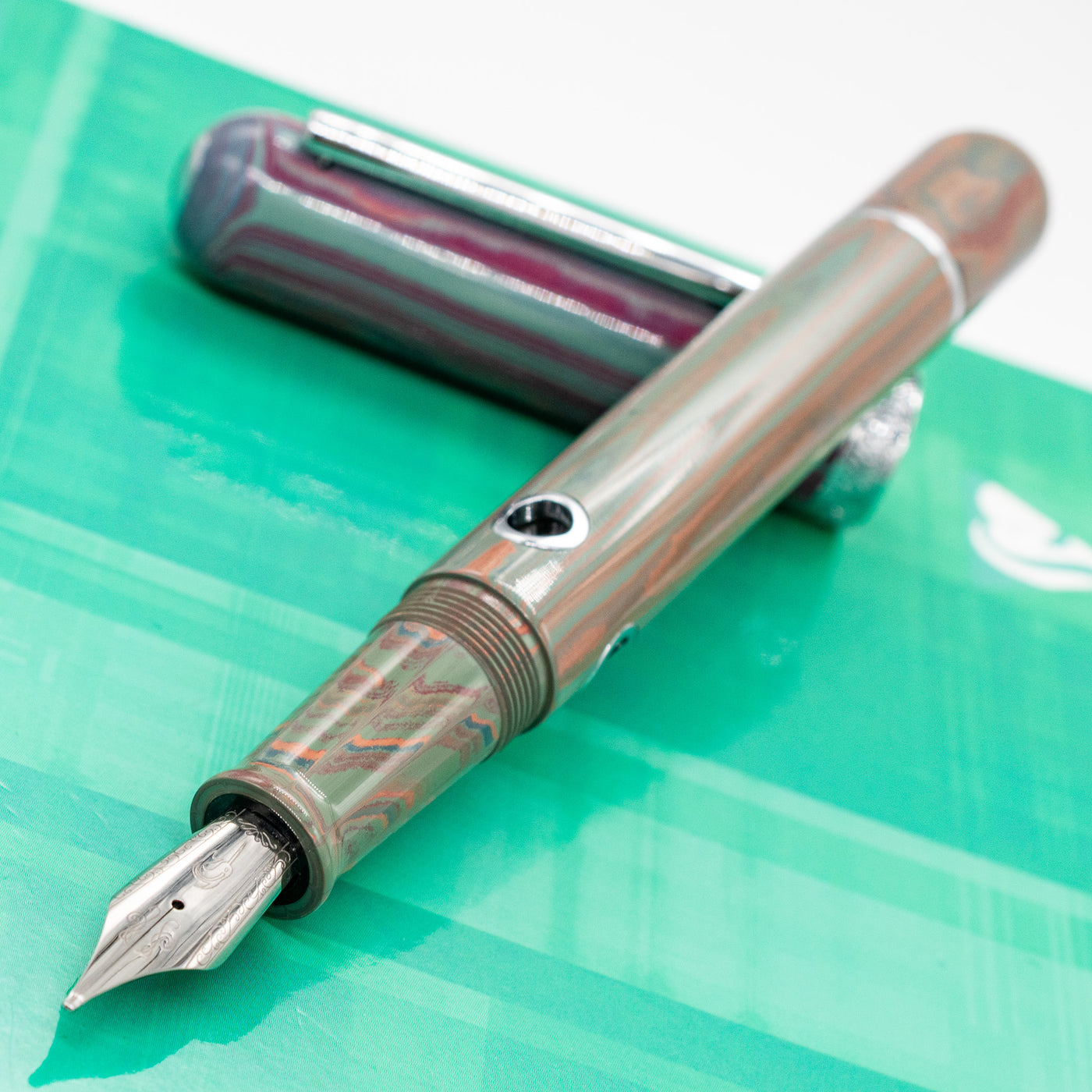 Uncapped Nahvalur Nautilus Rhapsody pen with visible nib and resin body – modern fountain pen with ocean-inspired marbled finish