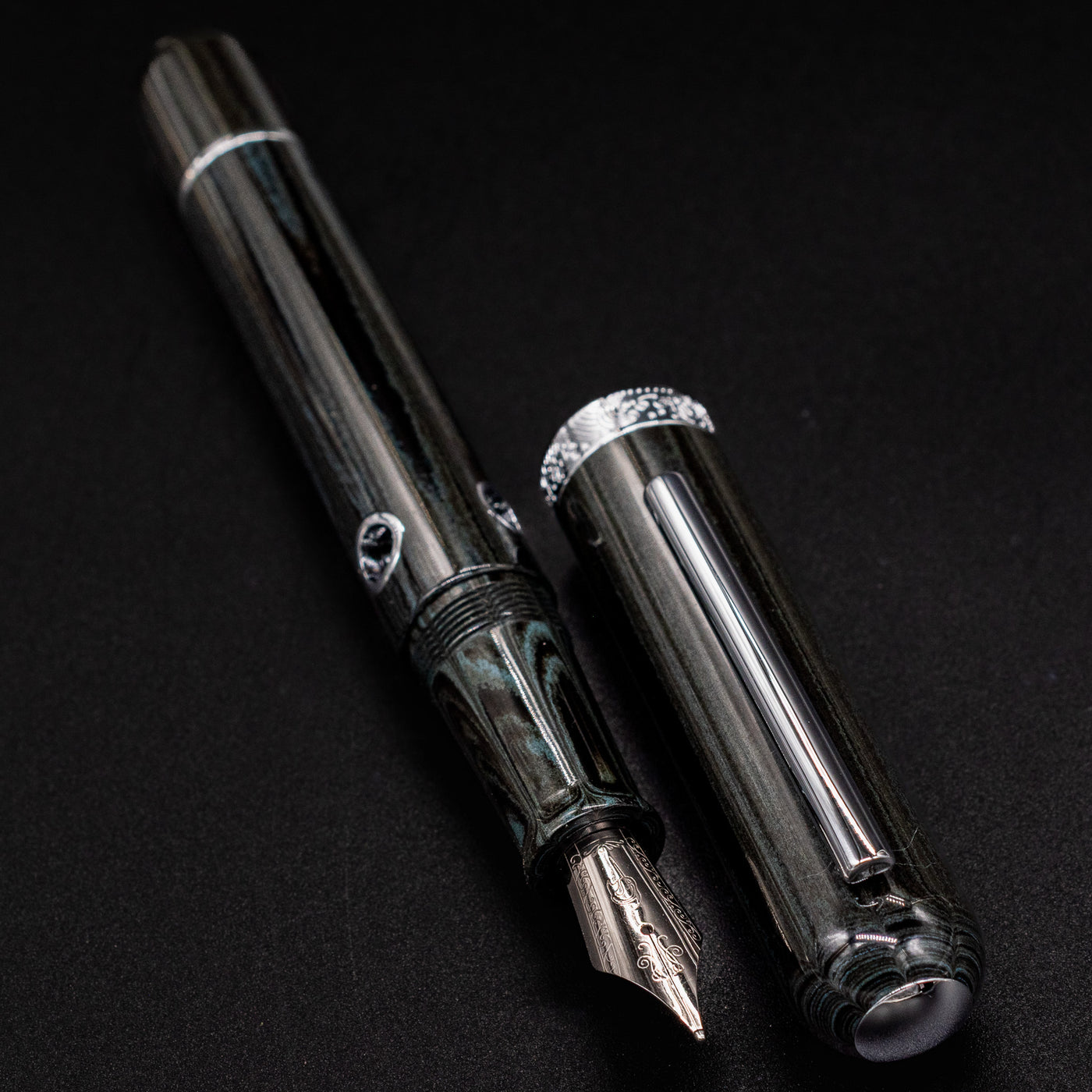 Nahvalur Nautilus Leviathan cap close-up – chrome clip and finial detail on deep umber ebonite cap