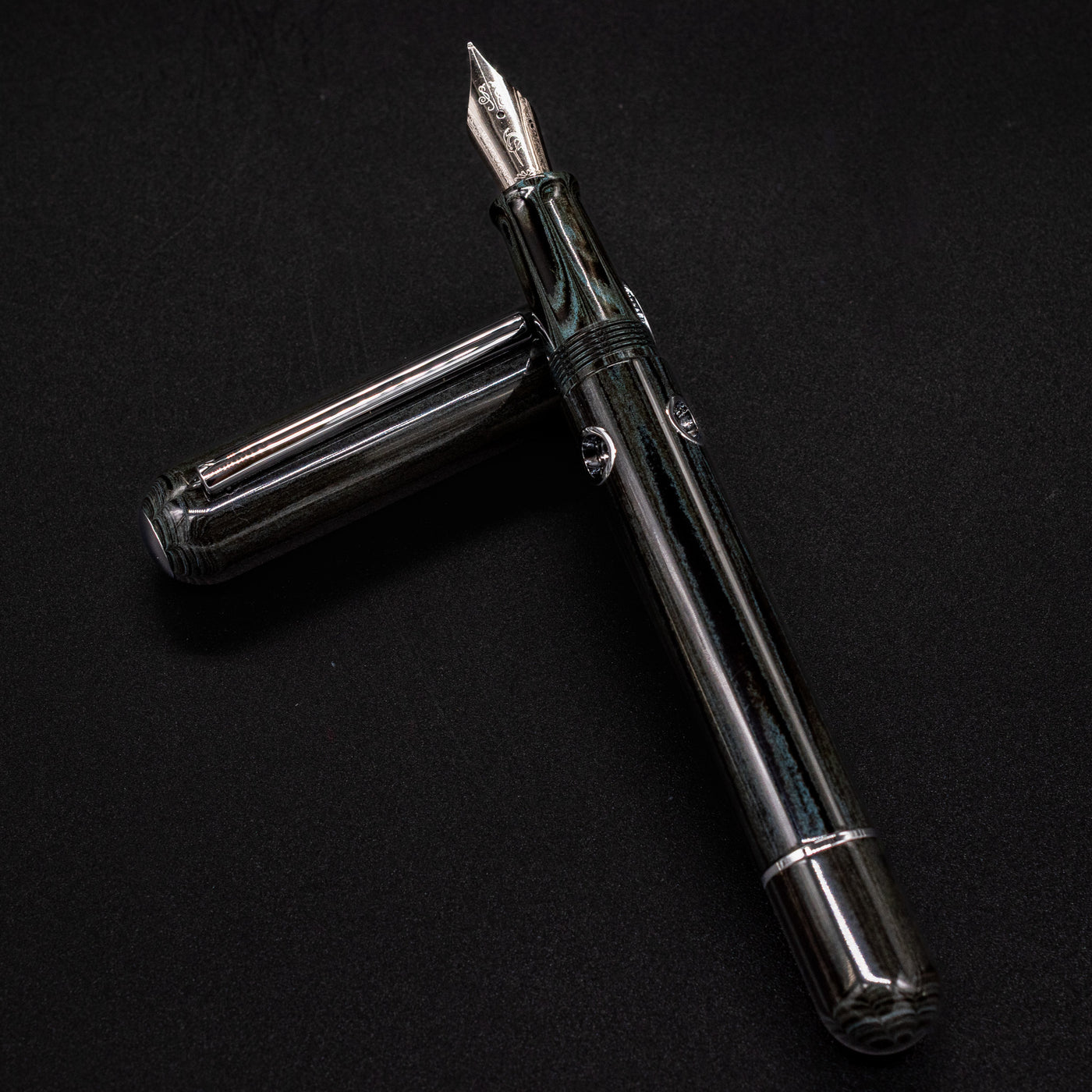 Close-up of Nahvalur Leviathan umber ebonite texture – dark green-black resin with natural swirling pattern