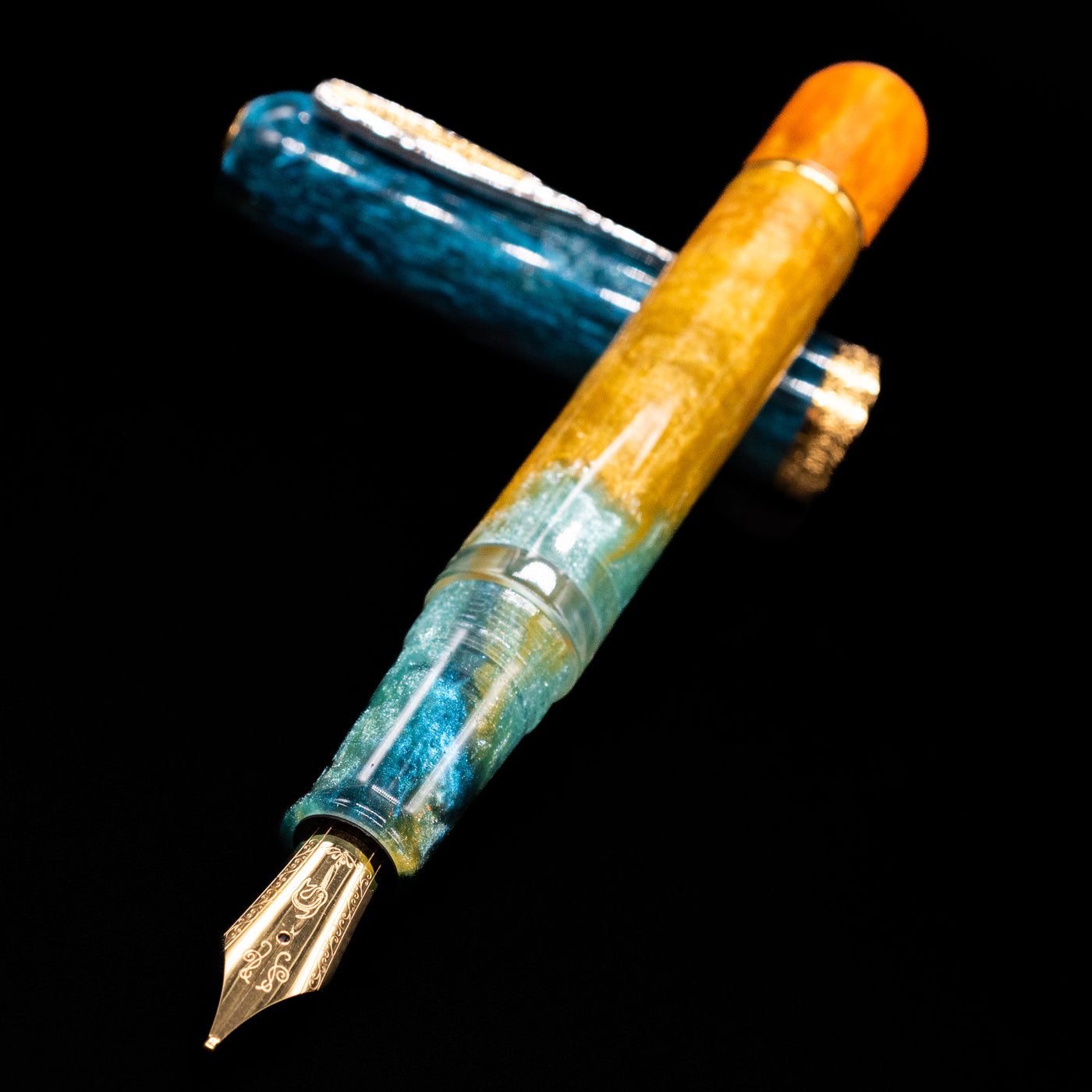 Nahvalur Voyage Fountain Pen - Hawaii laying across its own cap, crossed, with a focus on the nib.