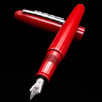 Nakaya Portable Writer Fountain Pen - AraiShu laying across its own cap, crossed, with a focus on the nib.