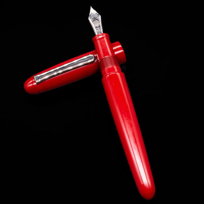 Nakaya Portable Writer Fountain Pen - AraiShu laying on top of its cap in a crossed position showing full view of the entire uncapped pen.