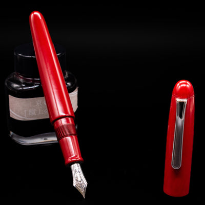Nakaya Portable Writer Fountain Pen - AraiShu leaning on an ink bottle uncapped showcasing the detailing on the nib.