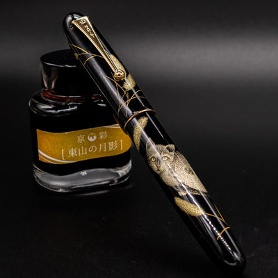 Capped pen resting atop ink bottle – Displaying the Yukari Royale’s elegant proportions and glossy urushi finish.