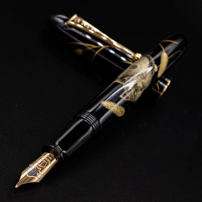 Uncapped pen leaning toward the camera – Capturing the rich luster of hand-applied urushi lacquer and the fine texture of gold inlay.