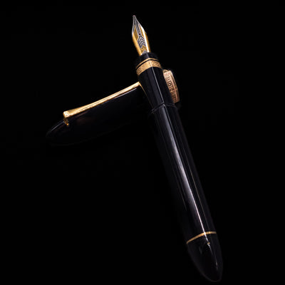 OMAS 360 Dark Blue Fountain Pen - Preowned laying on top of its cap in a crossed position showing full view of the entire uncapped pen.