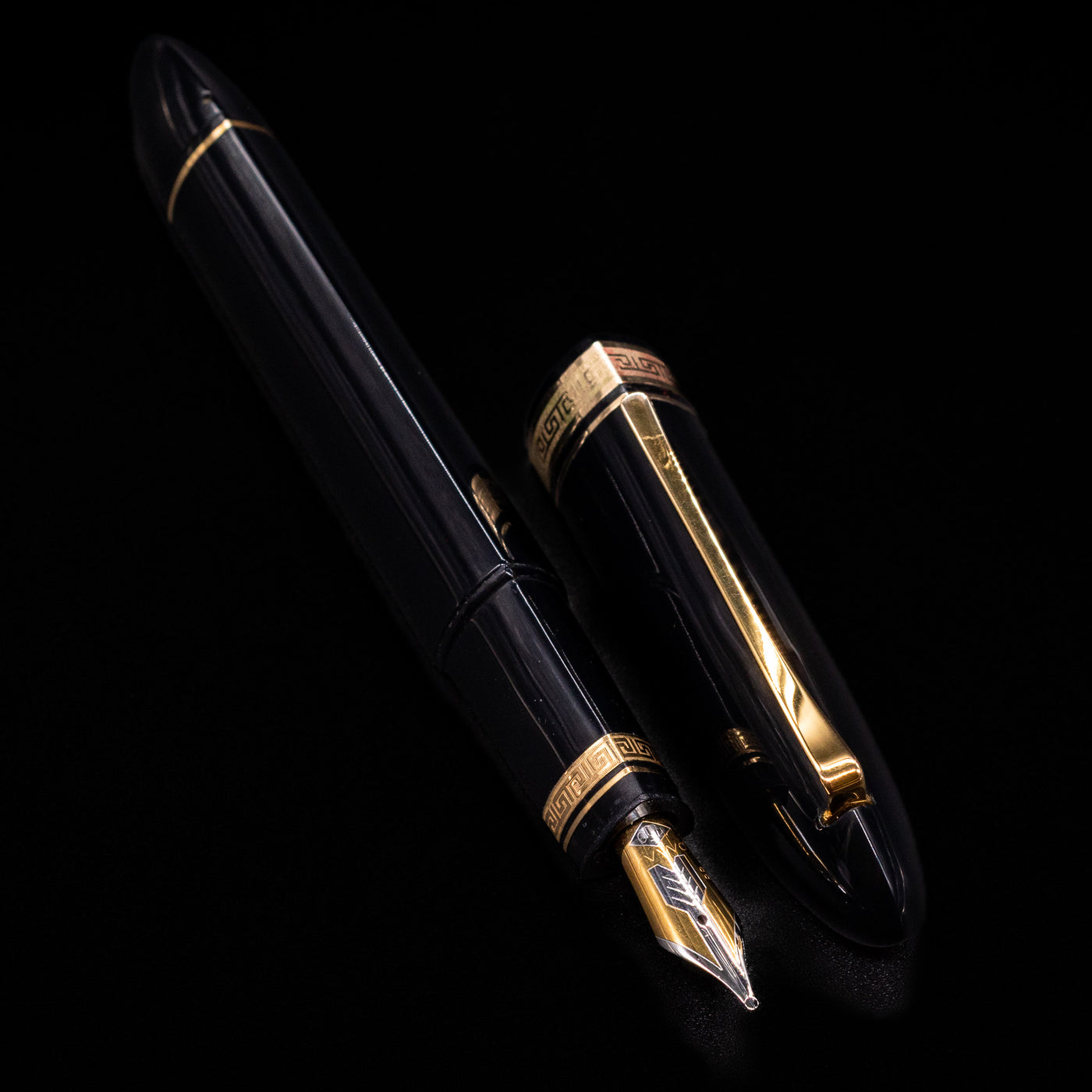 A full view of the OMAS 360 Dark Blue Fountain Pen - Preowned uncapped, with its cap laying next to the pen. 
