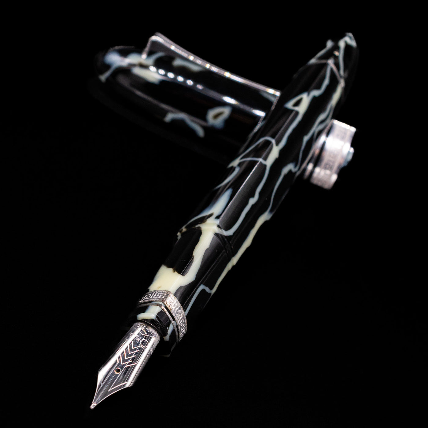 Preowned OMAS 360 Wild Celluloid fountain pen and cap crossed, with focus on the engraved silver nib and the rich marbled colors of the celluloid body.