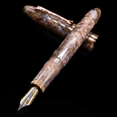 OMAS Ogiva Cocktail Series Fountain Pen - Espresso Martini laying across its own cap, crossed, with a focus on the nib.