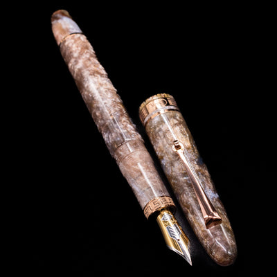 A full view of the OMAS Ogiva Cocktail Series Fountain Pen - Espresso Martini uncapped, with its cap laying next to the pen. 