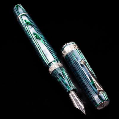  A full view of the OMAS Paragon Fountain Pen - Arco Verde uncapped, with its cap laying next to the pen.