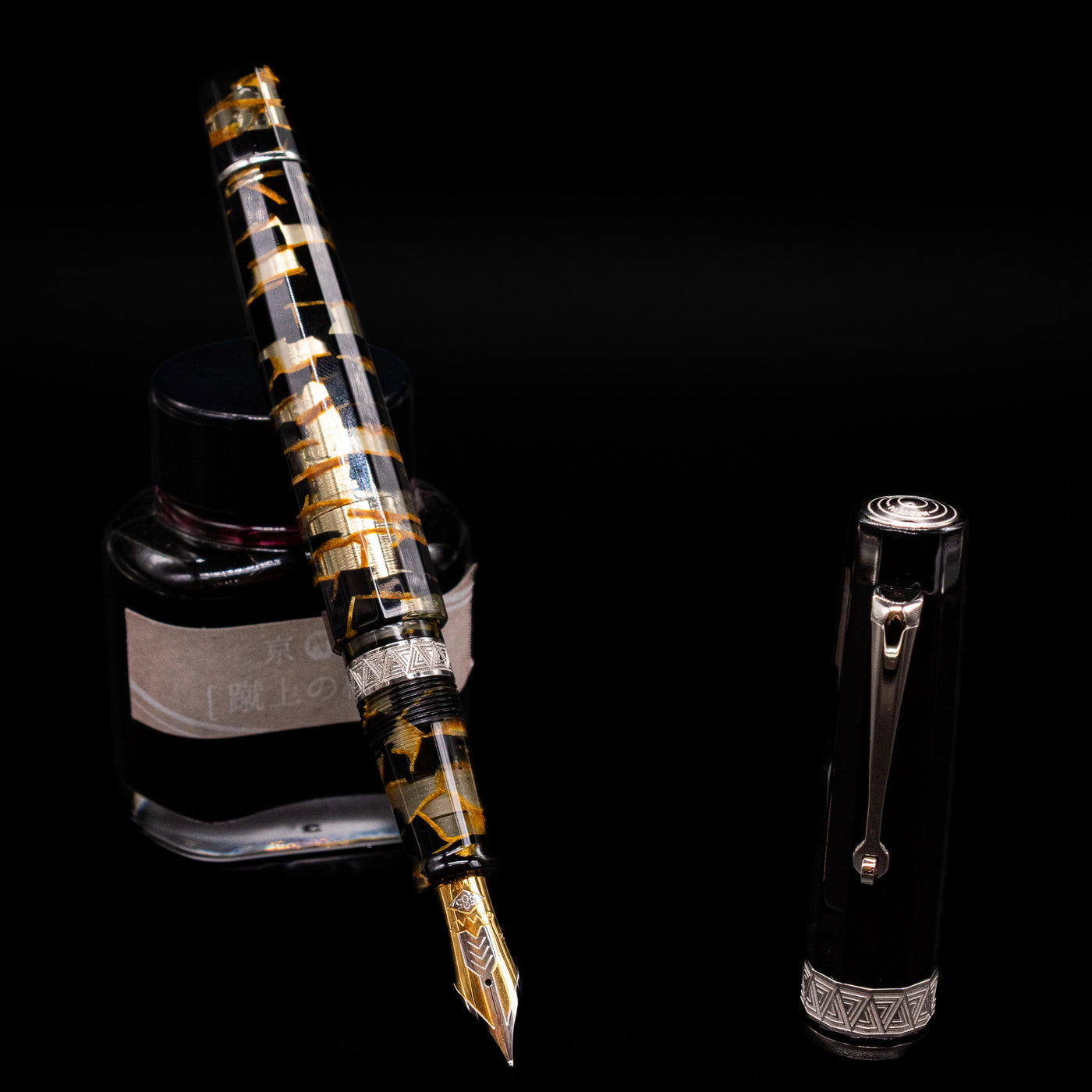 OMAS Paragon Fountain Pen - Black Lucen leaning on an ink bottle uncapped showcasing the detailing on the nib.
